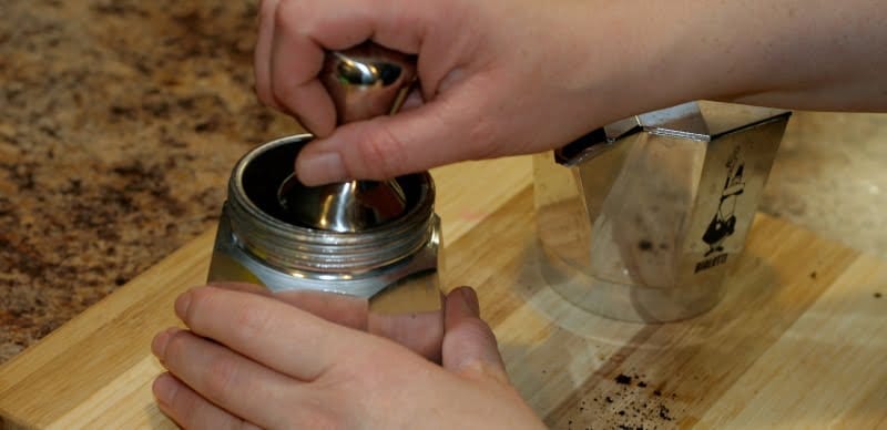 tamping coffee grounds in moka pot basket